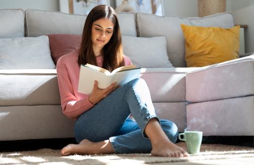 Girl reading near her couch